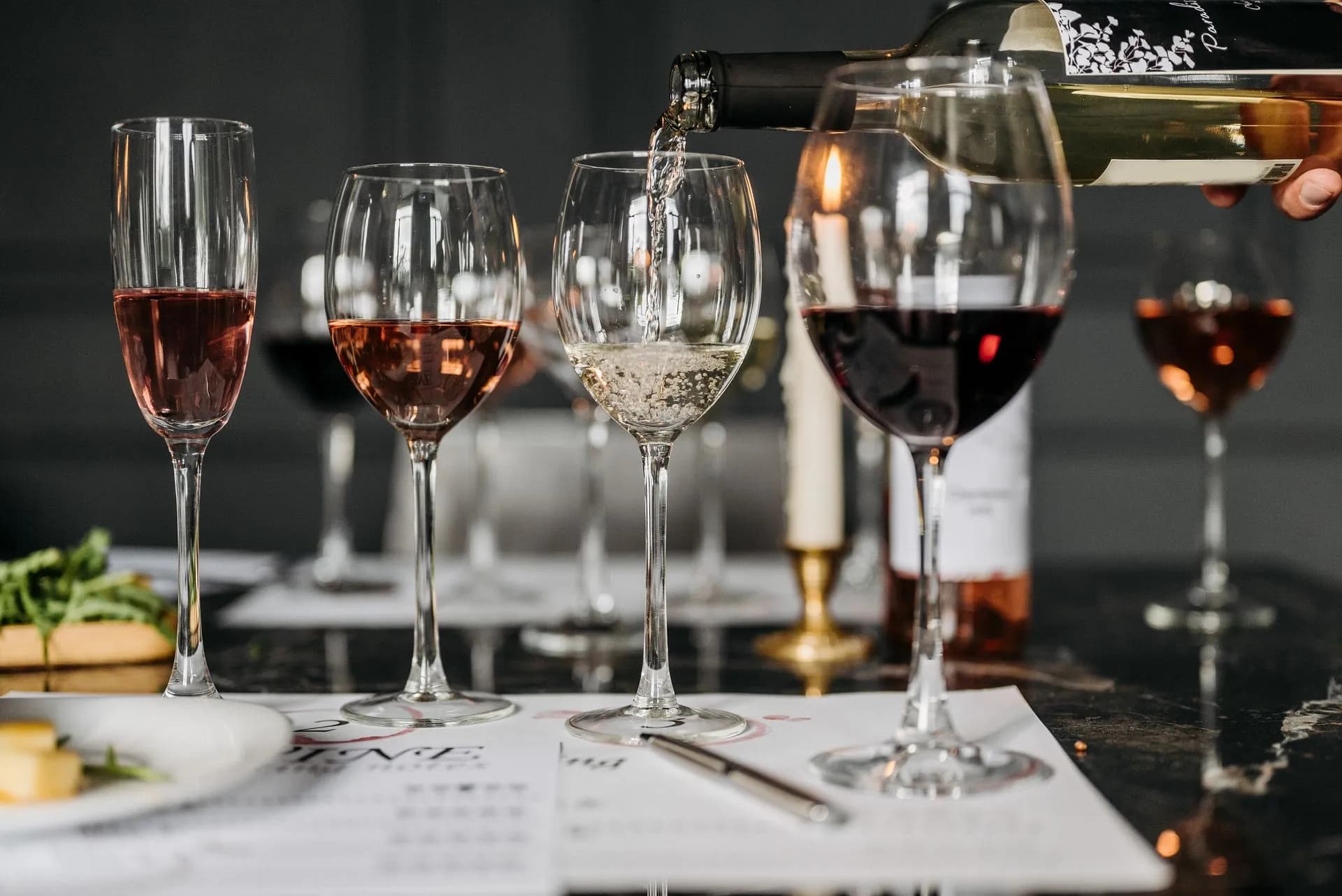 Glasses of Greek white and red wine on a terrace table with the floodlit Acropolis behind
