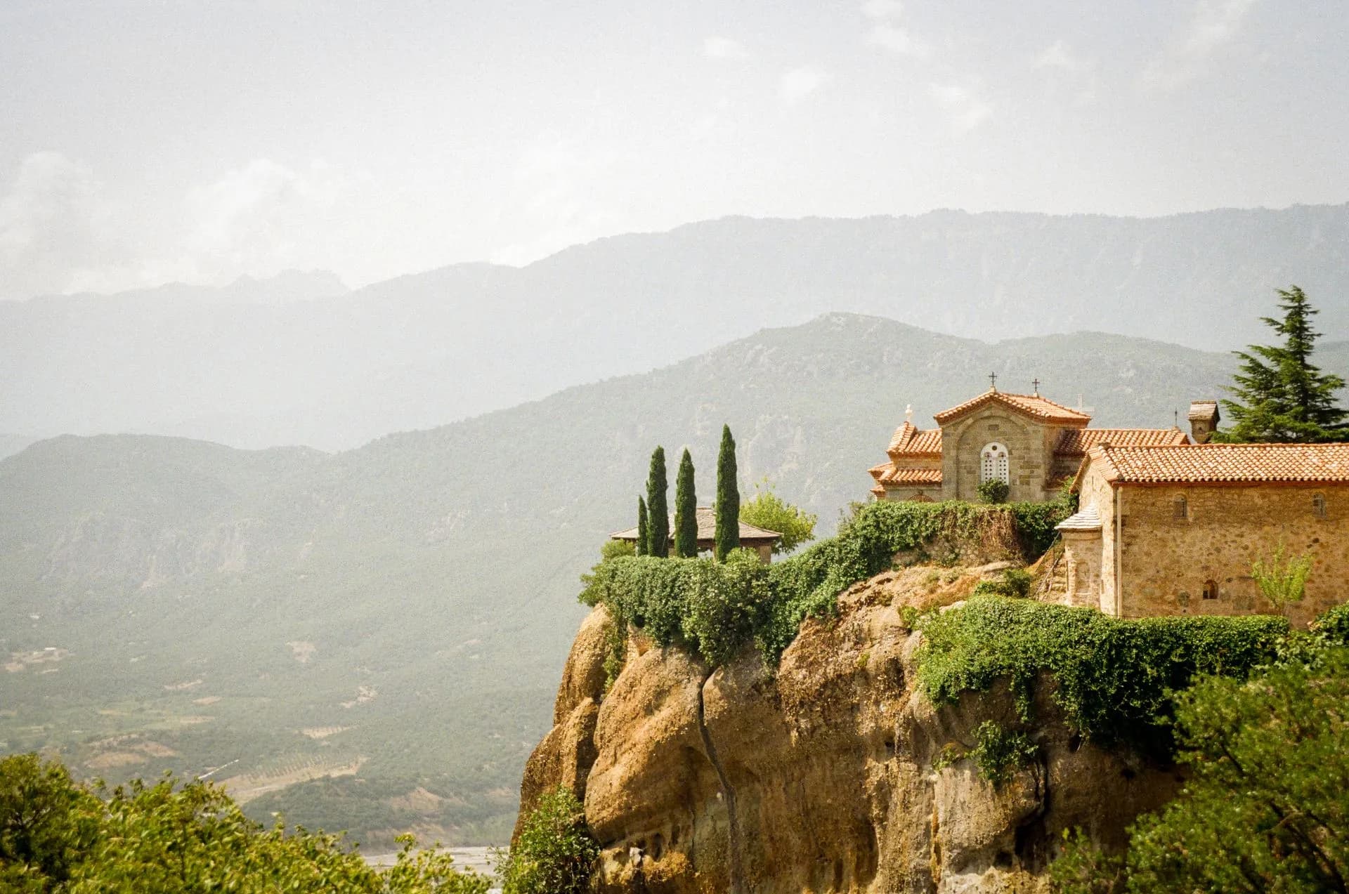 Monastery perched on a sandstone pillar above the Thessaly plain at Meteora in morning mist